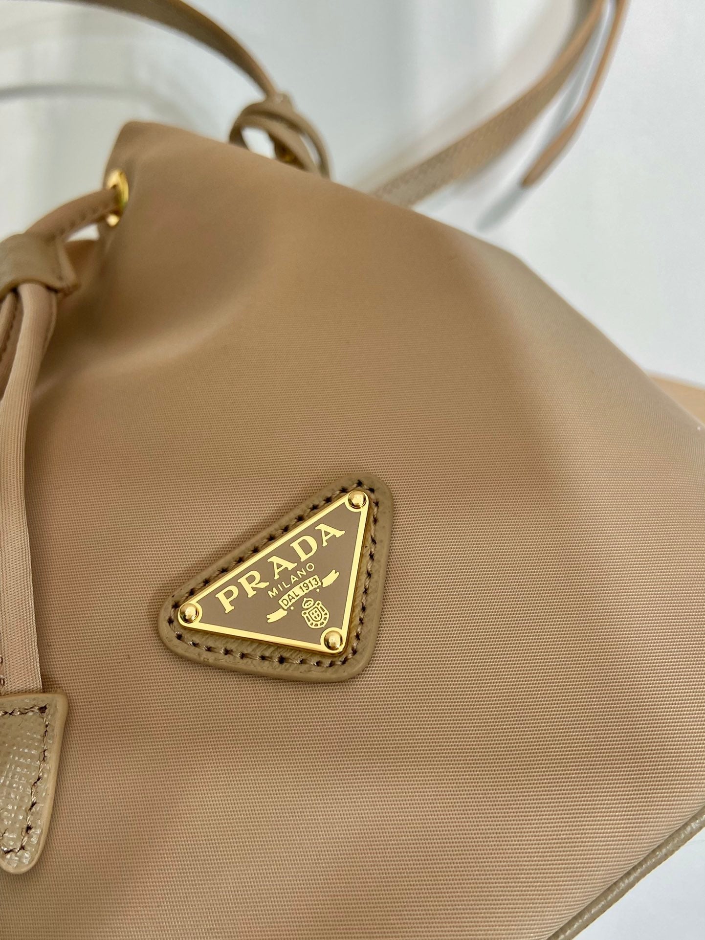 Luxury PradaBUCKET BAG 19 IN BEIGE RE-NYLON AND SAFFIANO LEATHER HANDLE