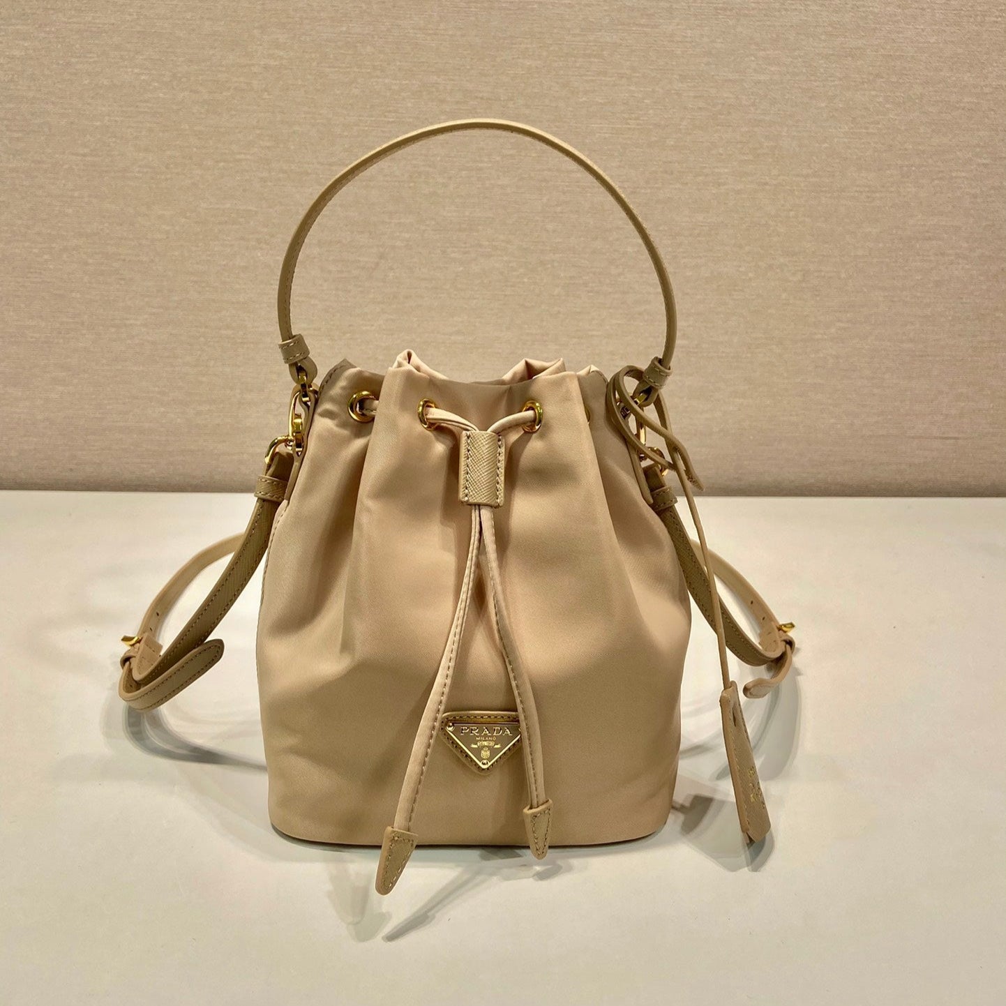Luxury PradaBUCKET BAG 19 IN BEIGE RE-NYLON AND SAFFIANO LEATHER HANDLE