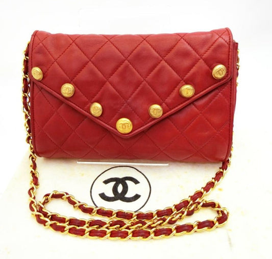 CHANEL Vintage red lamb leather shoulder bag with golden CC button motifs at flap
