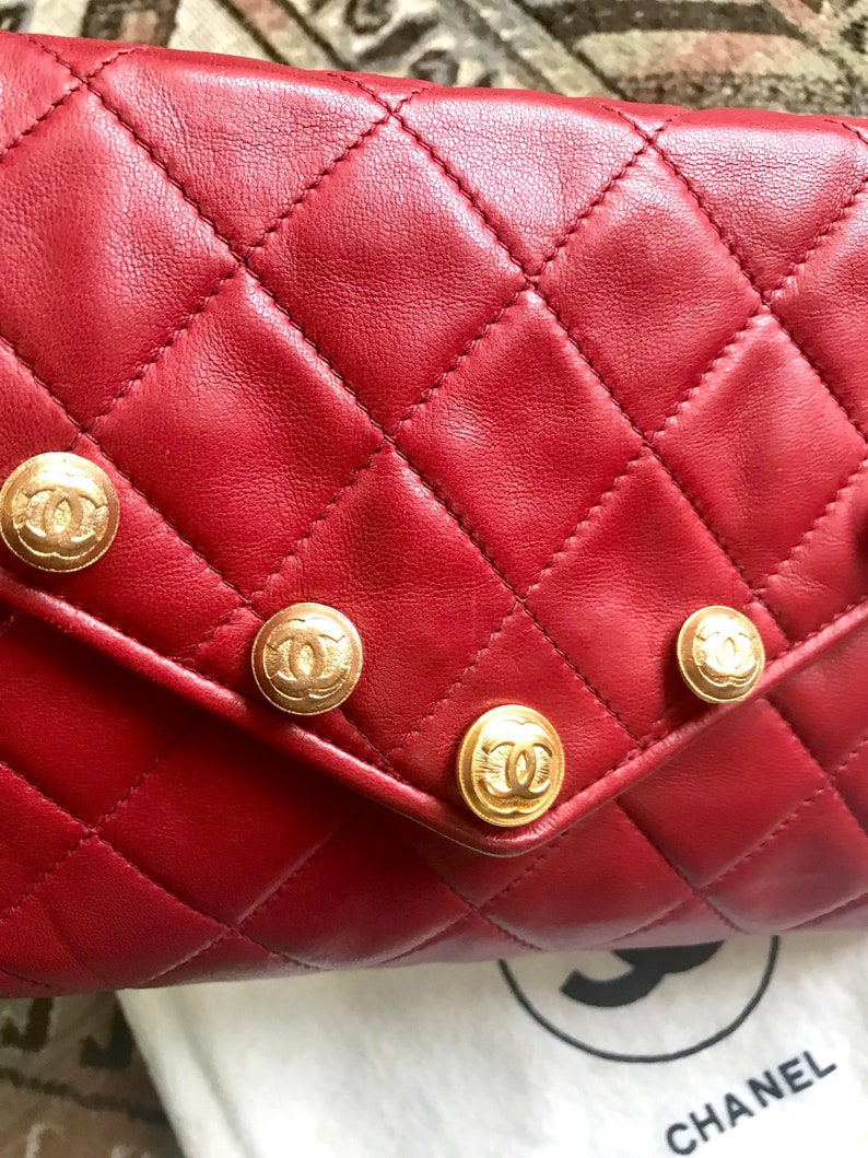 CHANEL Vintage red lamb leather shoulder bag with golden CC button motifs at flap