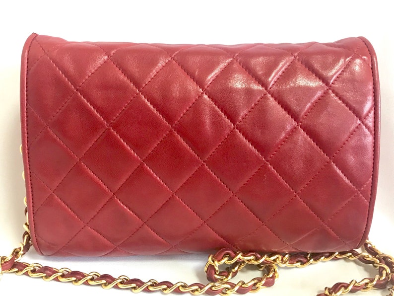 CHANEL Vintage red lamb leather shoulder bag with golden CC button motifs at flap