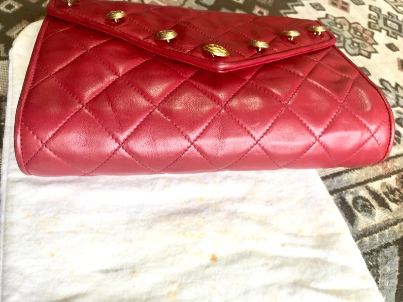 CHANEL Vintage red lamb leather shoulder bag with golden CC button motifs at flap