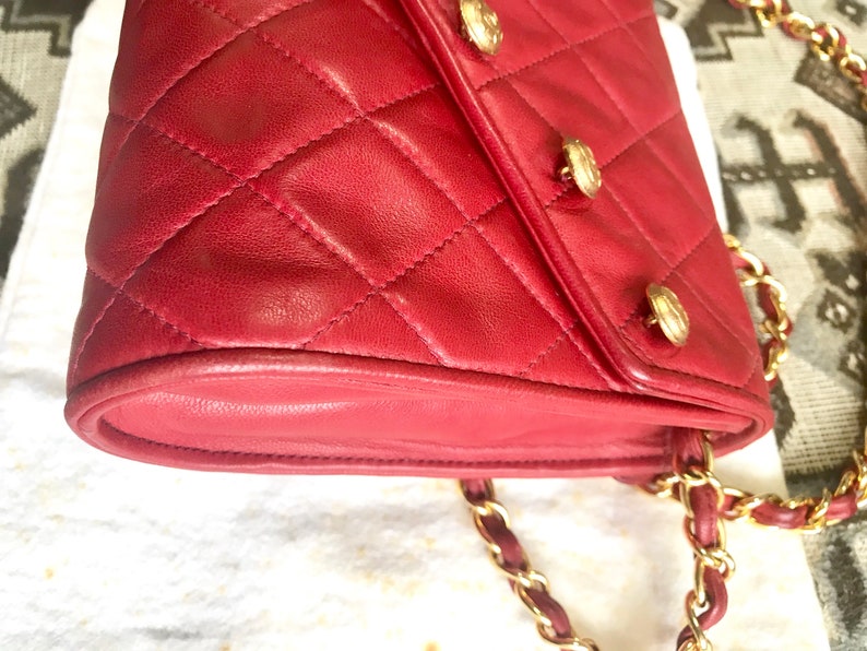 CHANEL Vintage red lamb leather shoulder bag with golden CC button motifs at flap