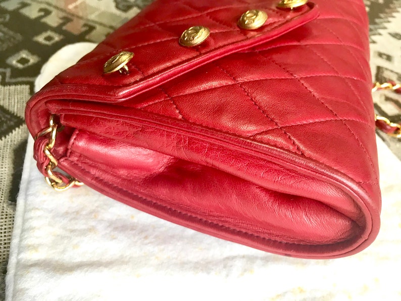 CHANEL Vintage red lamb leather shoulder bag with golden CC button motifs at flap