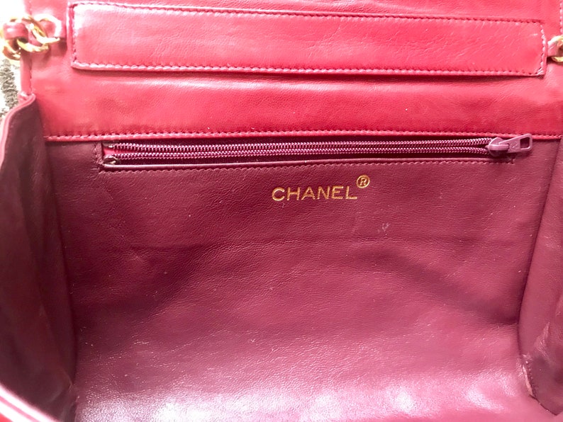 CHANEL Vintage red lamb leather shoulder bag with golden CC button motifs at flap