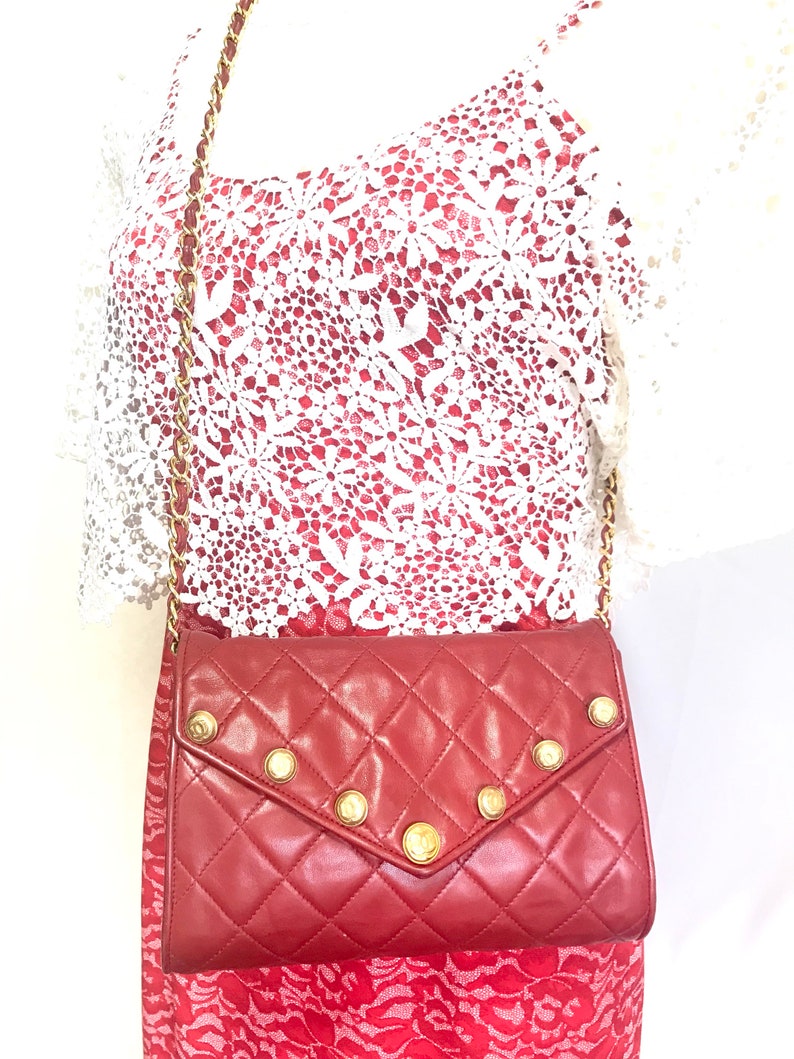 CHANEL Vintage red lamb leather shoulder bag with golden CC button motifs at flap