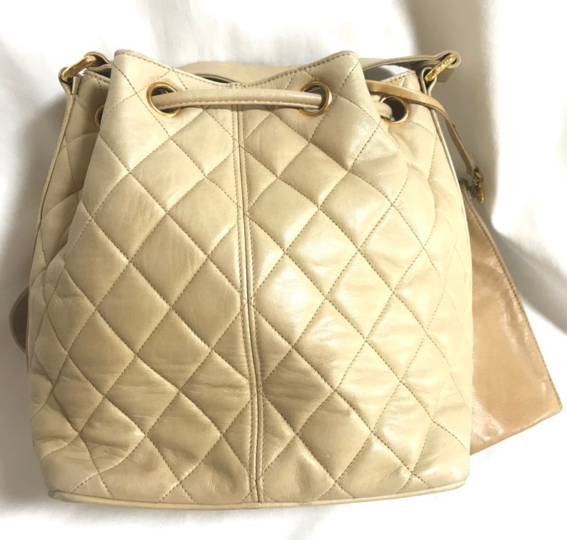 Luxury Chanel Vintage beige quilted lamb leather hobo bucket shoulder bag with drawstrings and golden CC mark ball