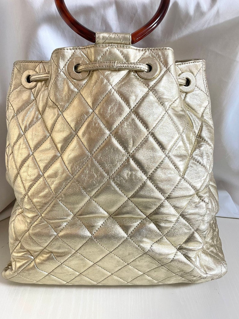 Luxury Chanel Vintage campaign gold lamb leather hobo bucket bag with marble hoop handles and turn lock CC