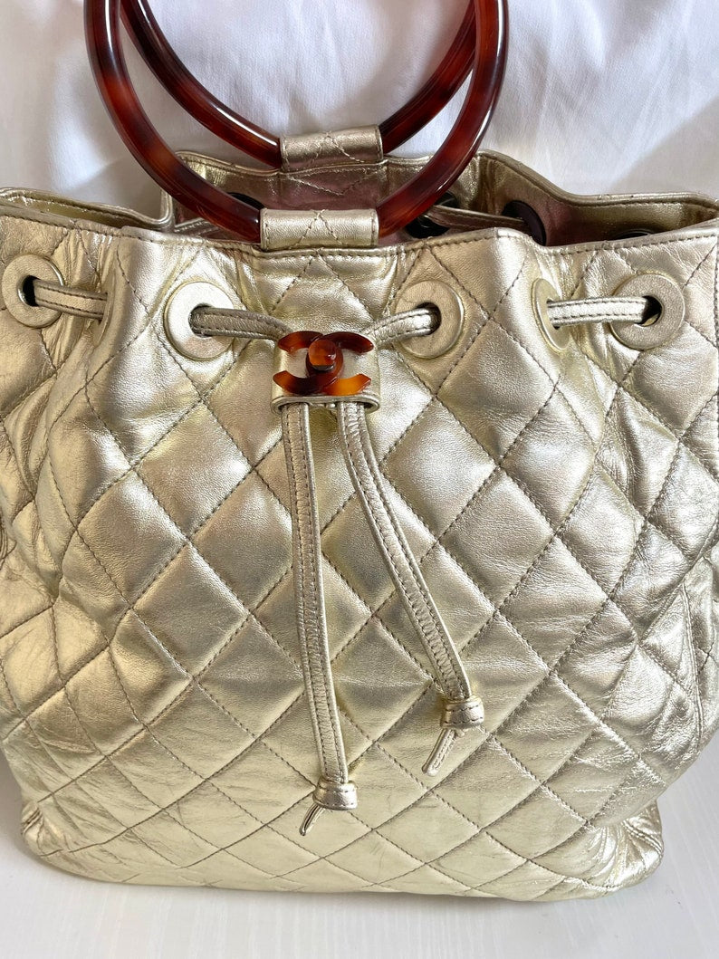 Luxury Chanel Vintage campaign gold lamb leather hobo bucket bag with marble hoop handles and turn lock CC